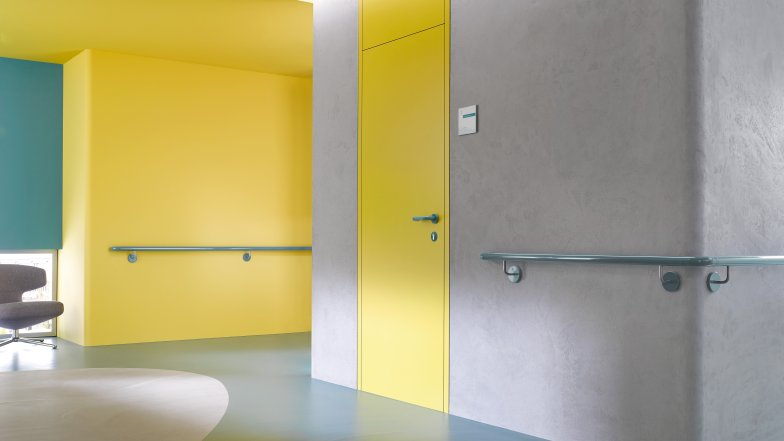 Corridor in a care building equipped with handrails in the colour aqua blue